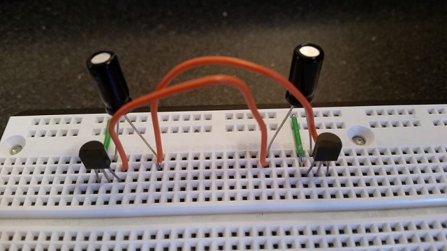 Kết nối cực dương của tụ điện đầu tiên tới collector của transistor 2